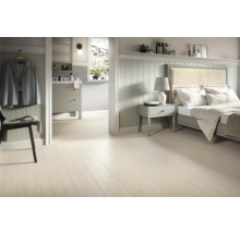 Helles Schlafzimmer mit Holzboden, Bett und Badezimmer im Hintergrund