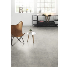 Heller Raum mit Sessel, Tisch und Kommode auf Fliesenboden.