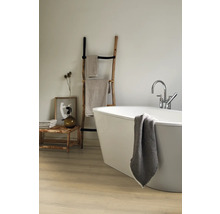 Badezimmer mit freistehender Badewanne, Handtuchleiter aus Holz und Badtextilien