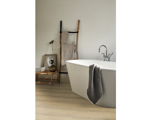 Badezimmer mit freistehender Badewanne, Handtuchleiter aus Holz und Badtextilien