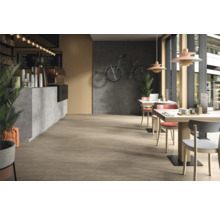 Innenansicht eines Cafés mit Tischen, Stühlen und einer Theke.