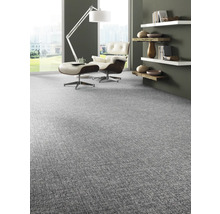 Wohnzimmer mit Teppichboden, Sessel, Hocker und Regalen