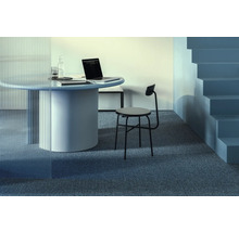 Szene mit rundem Tisch, Laptop, Stuhl und Treppe in einem modernen Büro.