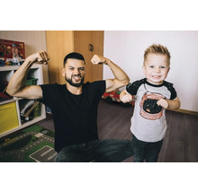 Vater und Sohn zeigen Muskeln im Kinderzimmer