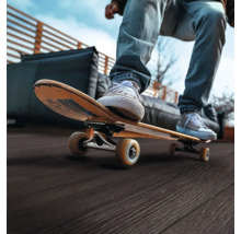 Person auf einem Skateboard auf einer Terrasse mit Holzboden