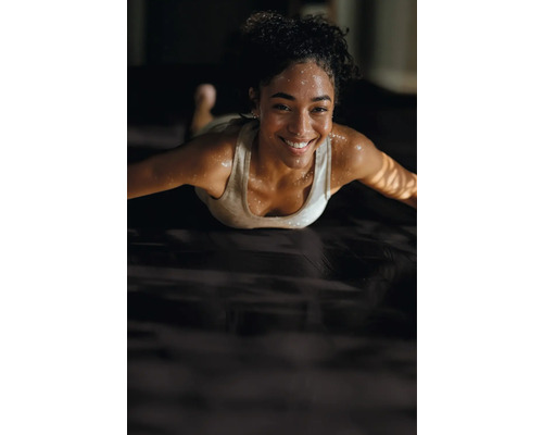 Frau trainiert auf einer Trainingsmatte.