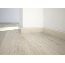 Heller Holzboden mit passenden Fußleisten an einer Wand