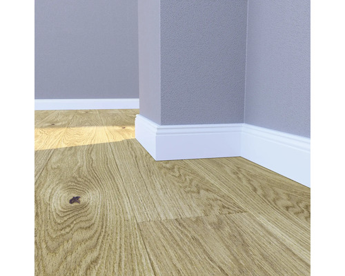 Raumecke mit Laminatboden und weißen Sockelleisten