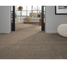 Beige Teppichboden in einem Wohnzimmer mit heller Couch und dekorativem Pouf