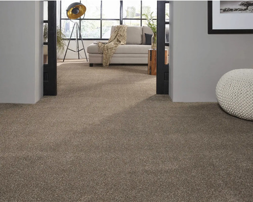 Beige Teppichboden in einem Wohnzimmer mit heller Couch und dekorativem Pouf