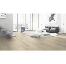 Heller Wohnraum mit Holzboden, Treppe, Sitzgelegenheit, rundem Teppich und Fernseher