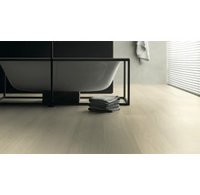 Badezimmer mit Badewanne, Handtüchern und hellem Holzboden