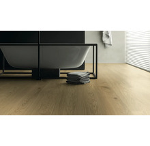 Badezimmer mit Badewanne, Handtüchern und hellem Holzboden