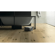 Badezimmer mit freistehender Badewanne, Handtüchern und Holzboden