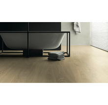 Modernes Badezimmer mit freistehender Badewanne, Handtüchern und hellem Holzboden