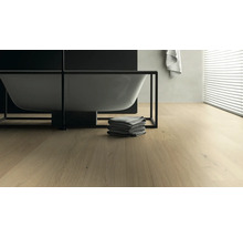 Badezimmer mit Badewanne, Handtüchern und Holzboden