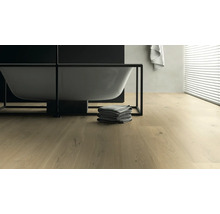 Badezimmer mit Badewanne, Handtüchern und hellem Holzboden