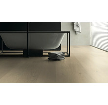 Modernes Badezimmer mit freistehender Badewanne, Handtüchern und Holzboden