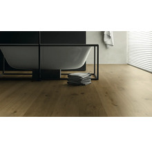 Badezimmer mit freistehender Badewanne, Handtüchern und Holzboden