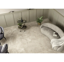 Heller Raum mit Steinfliesenboden, Sofa, Barwagen und Zimmerpflanze