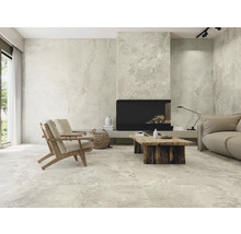 Heller Wohnraum mit Fliesenboden, Sesseln, Couch, Kamin und Holztisch