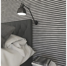 Schlafzimmer mit Bett, Wandpaneelen und verstellbarer Wandleuchte