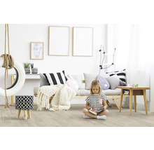 Kinderzimmer mit hellem Boden, Sofa, Bildern und spielendem Kind