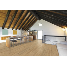 Helles Wohnzimmer mit Holzbalkendecke, Holzboden, Küchentheke und Stühlen