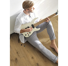 Mann mit E-Gitarre auf Holzboden