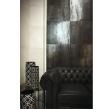 Szene mit dunklen Wandfliesen, schwarzem Ledersofa und dekorativen Vasen mit geometrischen Mustern