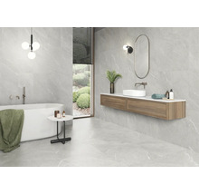 Badezimmer mit Badewanne, Waschtisch und grauen Fliesen in Marmoroptik