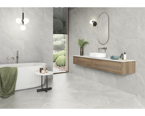 Badezimmer mit Badewanne, Waschtisch und grauen Fliesen in Marmoroptik