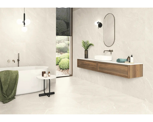 Badezimmer mit Badewanne, Waschtisch und Fliesen in Marmoroptik