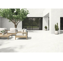 Terrasse mit hellem Bodenbelag, Sitzgruppe aus Holz und Bepflanzung