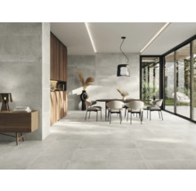 Heller Raum mit Steinfliesenboden, Esstisch und Schiebetüren zur Terrasse.