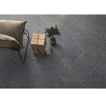 Verlegte Bodenfliesen mit Sessel, Beistelltisch, Topfpflanze und Büchern