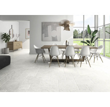 Heller Wohnraum mit Bodenfliesen, Esstisch und Stühlen.