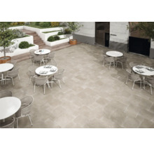 Außenbereich mit Bodenfliesen und Sitzgruppen aus Tischen und Stühlen.