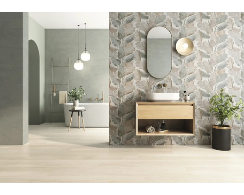 Badezimmer mit Badewanne, Waschtisch, Spiegel und Wandfliesen mit Blattmuster für ein helles, organisiertes Ambiente.