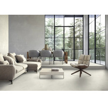 Helles Wohnzimmer mit Sofa, Sesseln, Esstisch und großem Fenster mit Blick auf Bäume