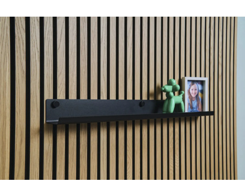 Schwarzes Wandregal vor einer Holzpaneelwand mit Dekoration