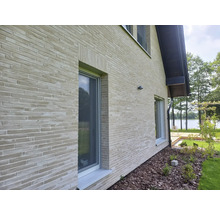 Außenansicht eines Hauses mit Ziegelmauerwerk und Fenstern