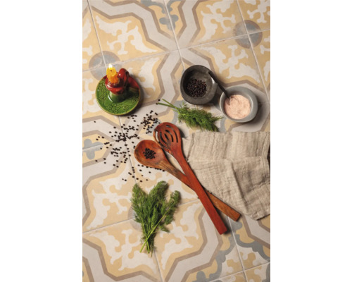 Dekorative Fliesen mit Kerzenständer, Kochlöffeln, Kräutern und Gewürzen