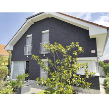 Außenansicht eines Hauses mit Fassade, Fensterrollläden und Bewuchs