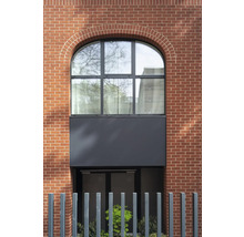 Fassade eines Gebäudes mit Backsteinmauerwerk und einem Bogenfenster