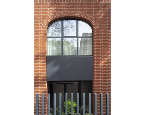 Fassade eines Gebäudes mit Backsteinmauerwerk und einem Bogenfenster