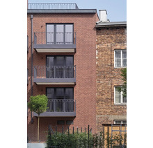 Fassade eines Mehrfamilienhauses mit Ziegelsteinen und Balkonen.