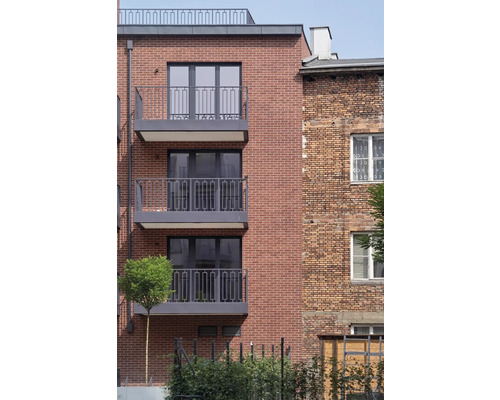 Fassade eines Mehrfamilienhauses mit Ziegelsteinen und Balkonen.