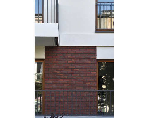 Fassade eines Gebäudes mit rotem Ziegelmauerwerk und Balkonen