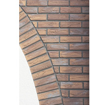 Nahaufnahme einer Mauerwerksfassade mit Ziegelsteinen in Bogenform